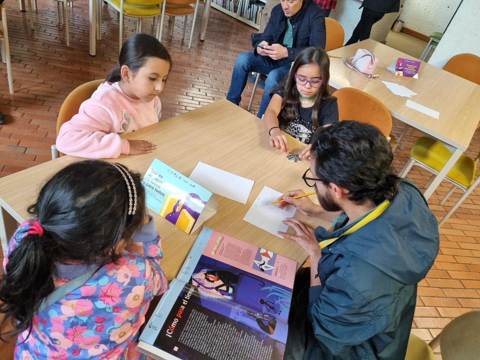 Infancias y sus cuidadores participando en actividades creativas en la biblioteca