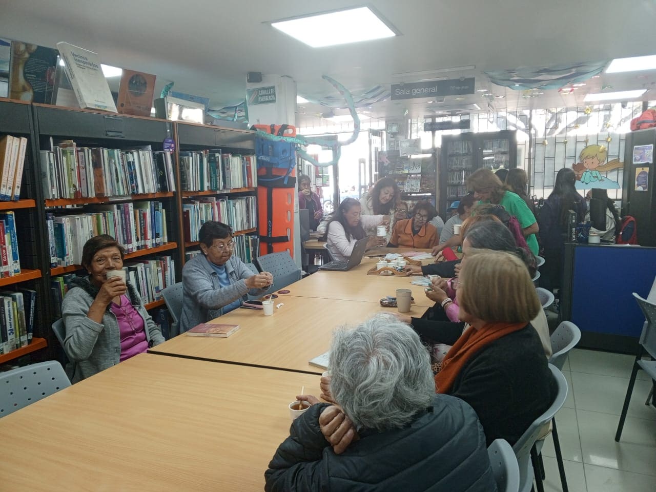 grupo de adultos reunidos conversando y tomando café