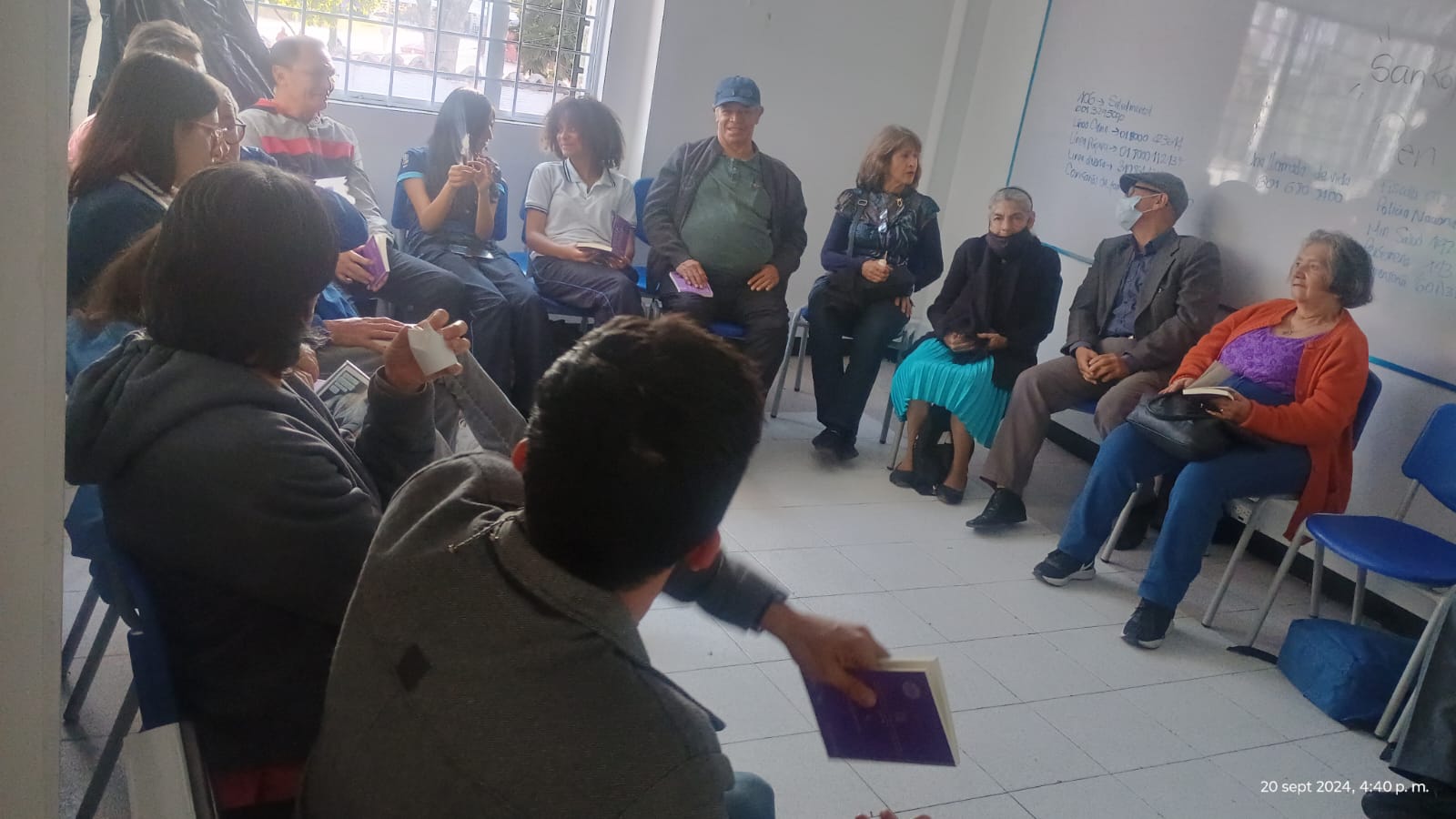 grupo de adultos mayores sentados en medio círculo conversando