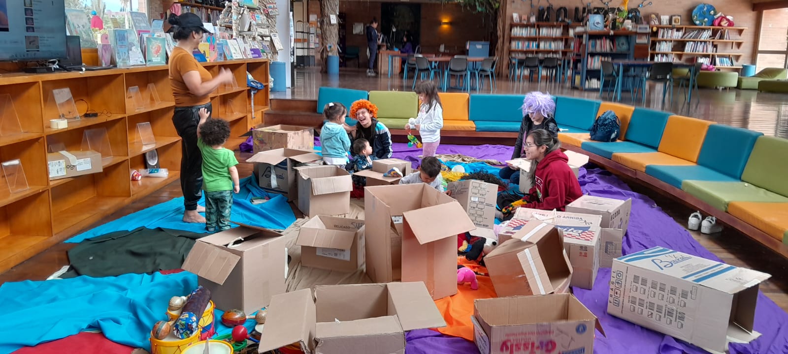 Sala infantil de la biblioteca con infancias participando en actividades