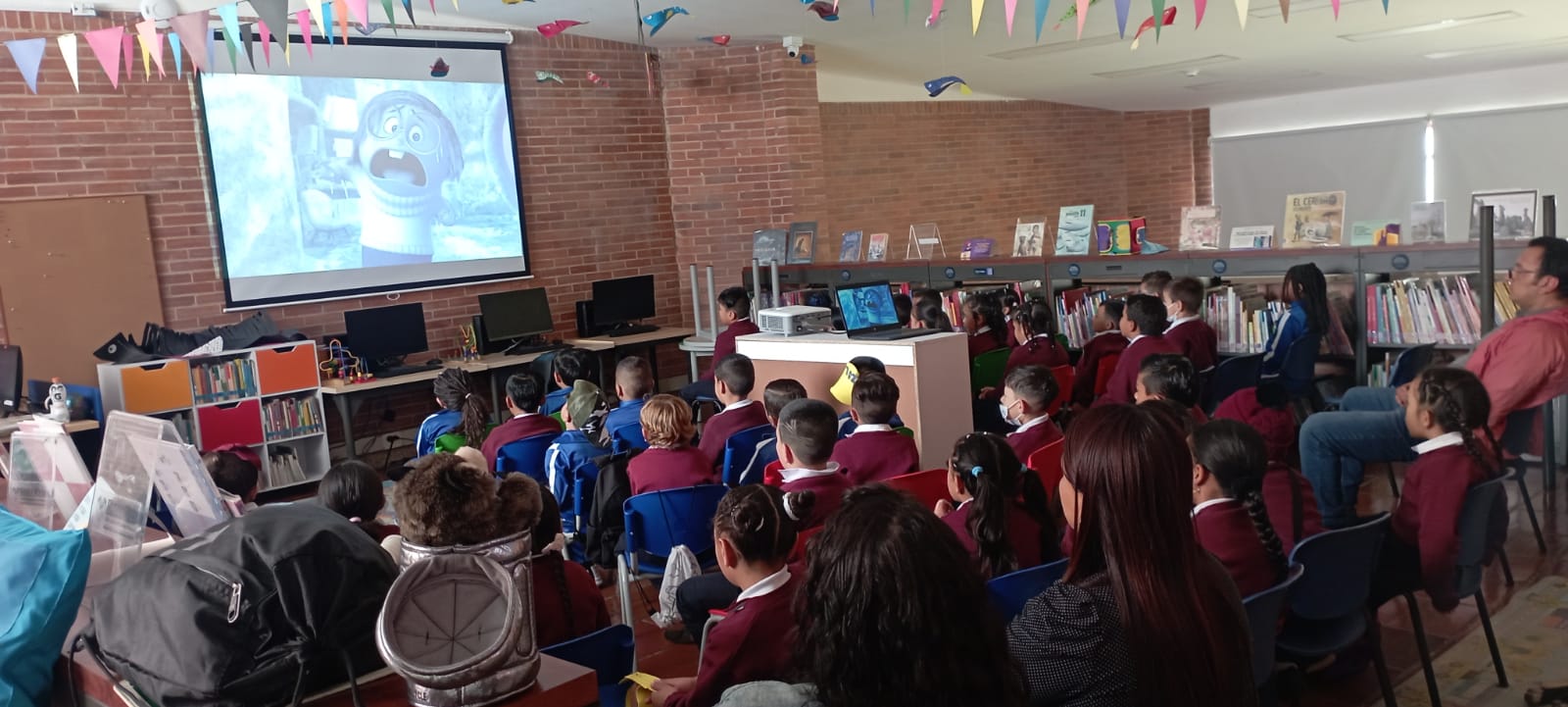 Niños participando de proyección en la biblioteca