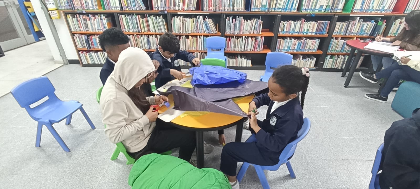 Infancias participando en el club de lectura infantil en la biblioteca