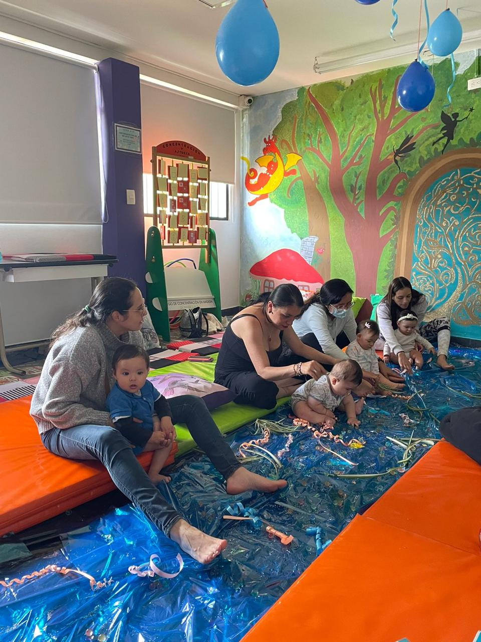 Bebés junto a sus cuidadores participando de experiencias sensoriales en la biblioteca