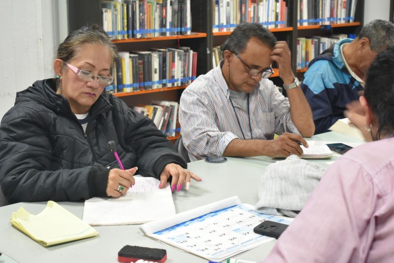 Personas participando en el club de lectura de la biblioteca