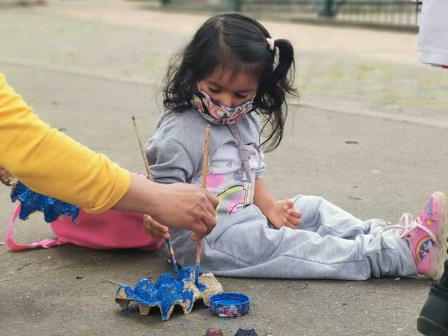 Niña pintando un cartón