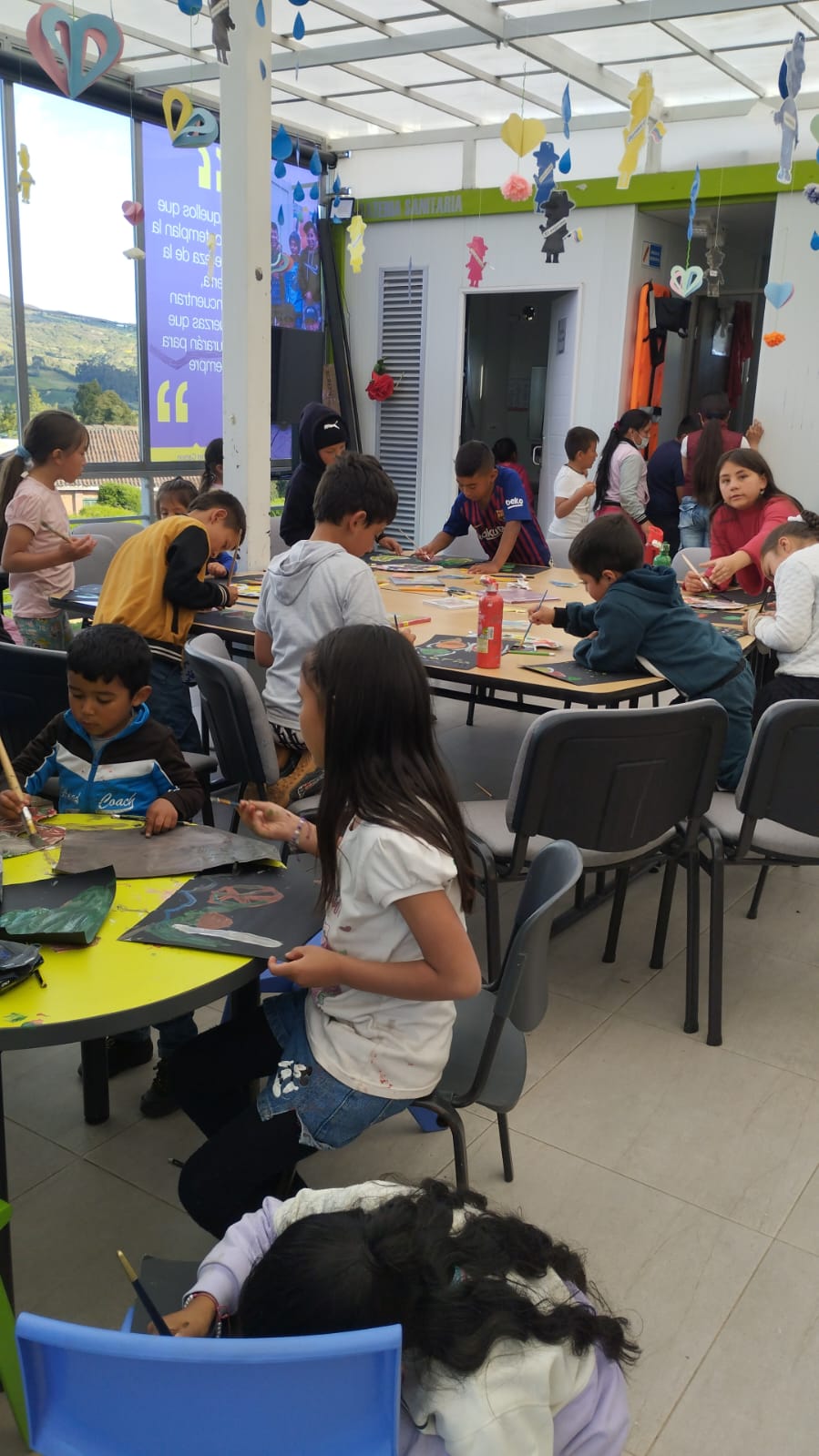 grupo de niños y niñas pintando y dibujando en medio de un taller