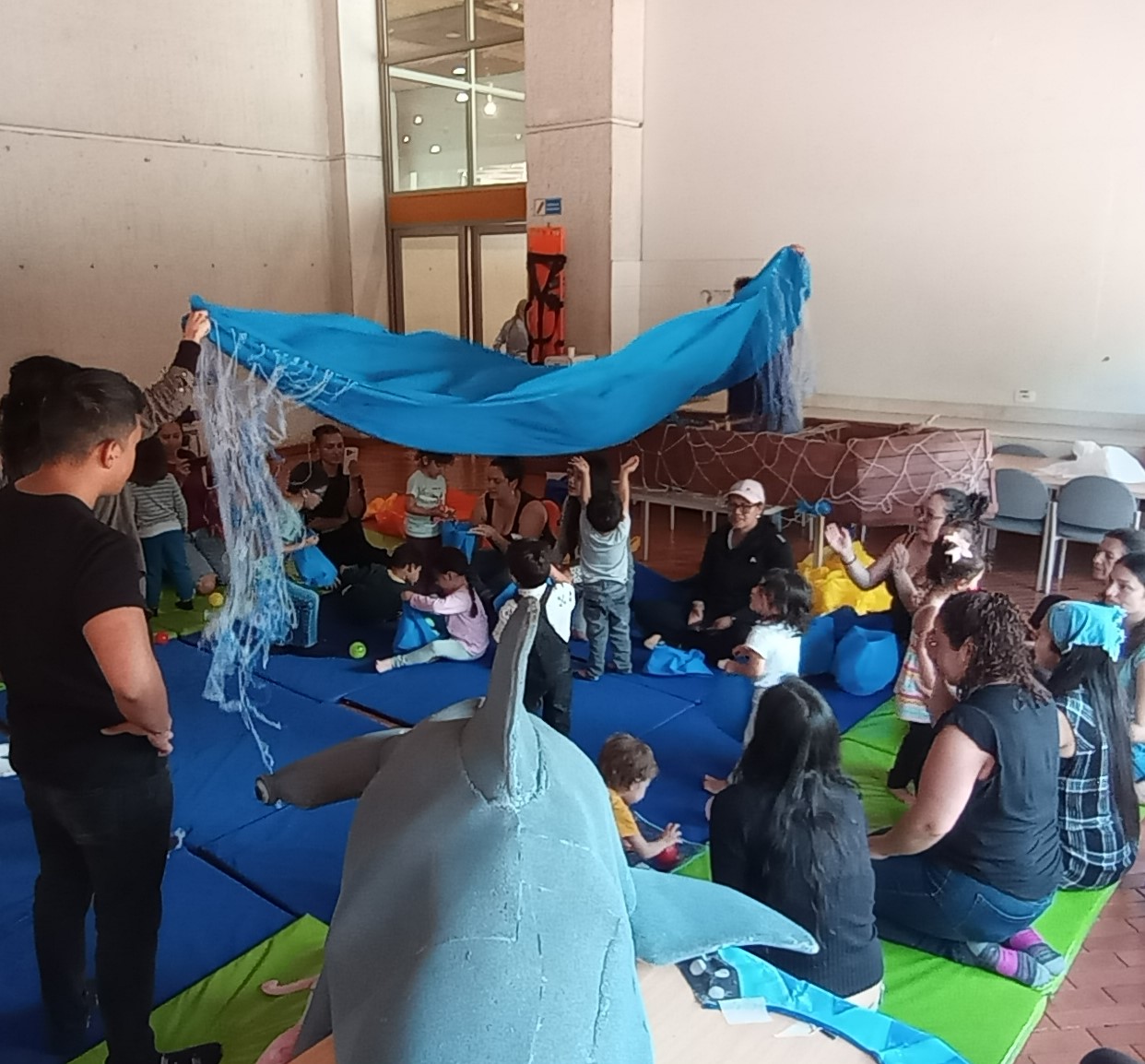 Cuidadores junto a sus bebés participando en actividades sensoriales y lúdicas en la biblioteca