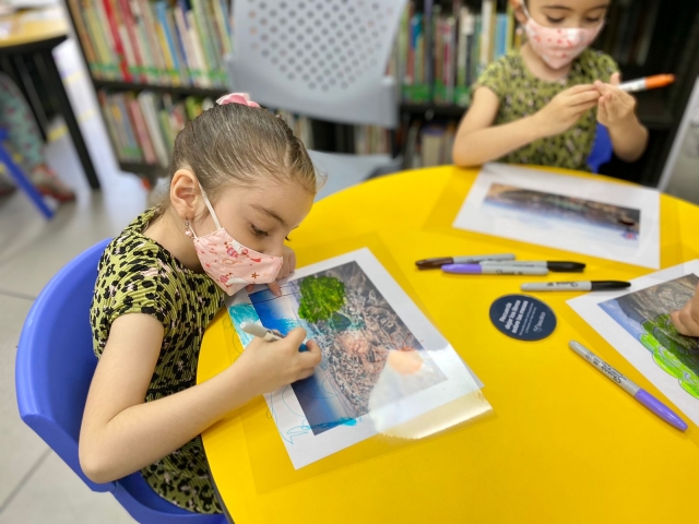 Infancias participando en el club de lectura infantil en la biblioteca