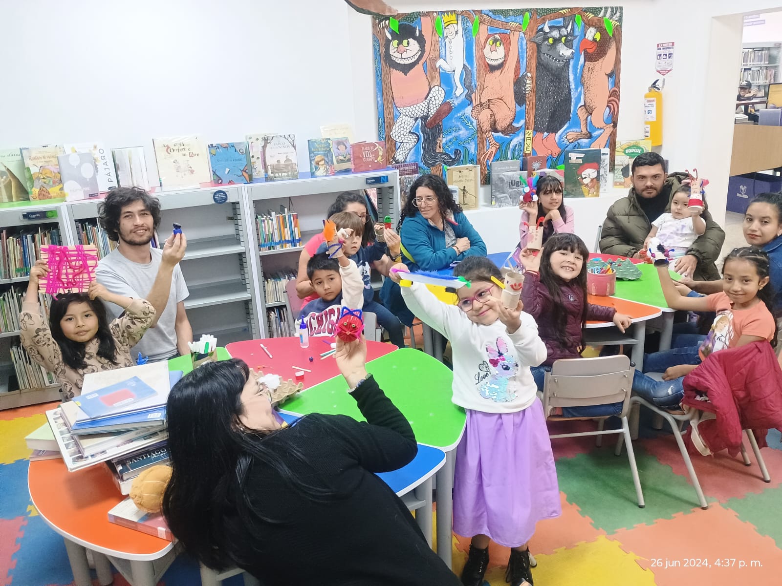 grupo de niñas y niños jugando con títeres realizados con  material reciclable