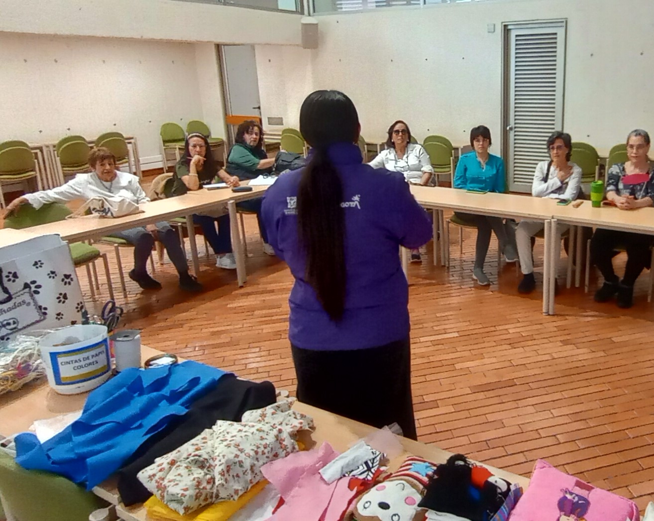 docente explicando una actividad a un grupo de mujeres