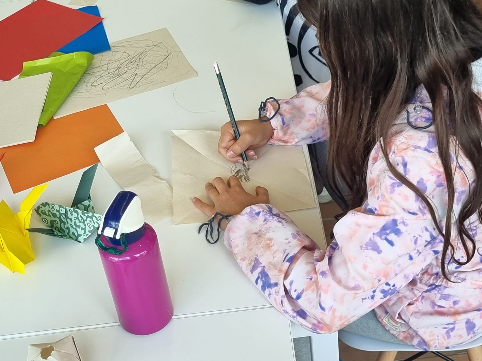 Infancia dibujando sobre una mesa en la biblioteca