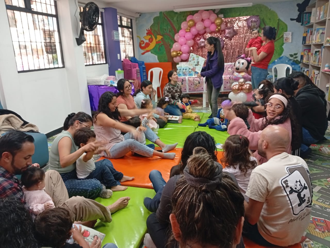 Exploración colorida niños viendo a una docente leyendo un libro
