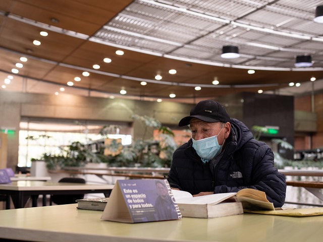 hombre leyendo en la biblioteca