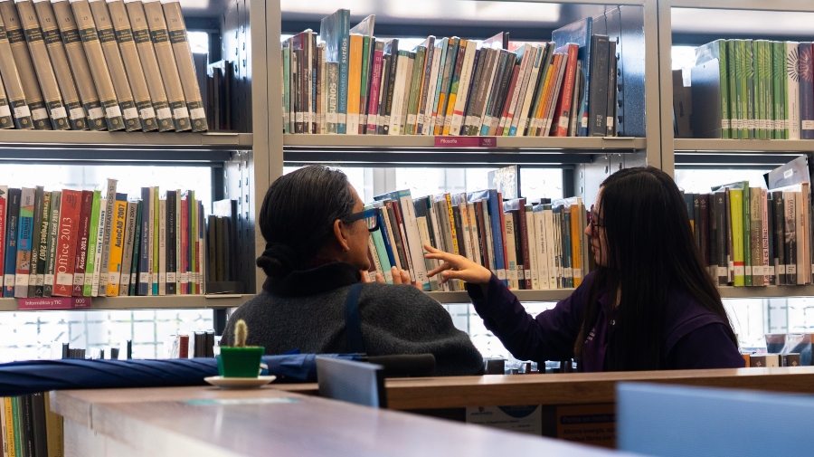 Usuarias de BibloRed observando las colecciones